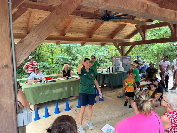 BIRD Program Volunteer talking to a group of people in front of the banding table