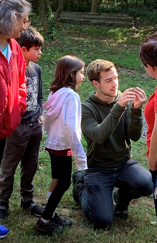 Volunteer holding hummingbird and showing children 