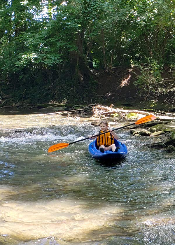 Young camper kayaking in the Little Harpeth River
