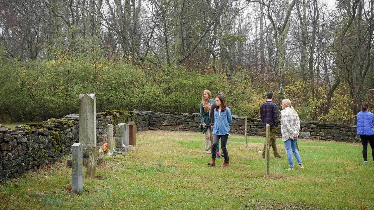 Group walking around historic cemetery.