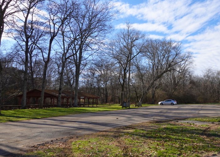 Parking lot with one car next to picnic shelter