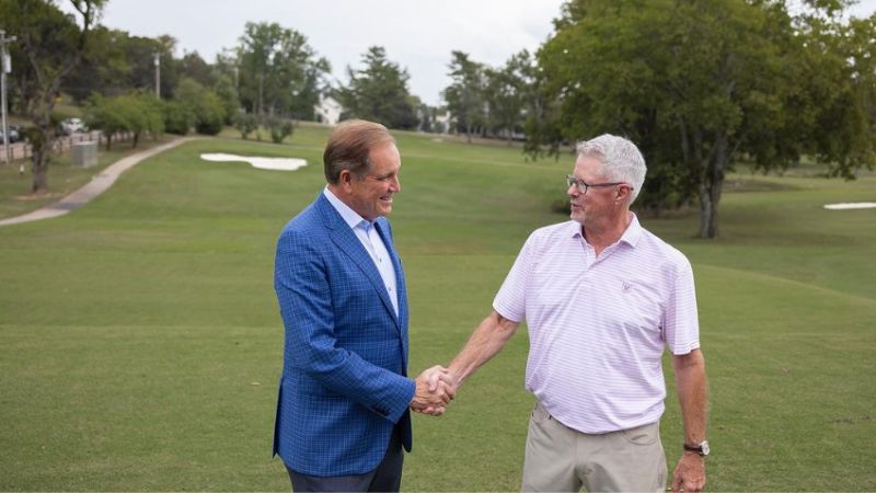 Two men shaking hands on golf course