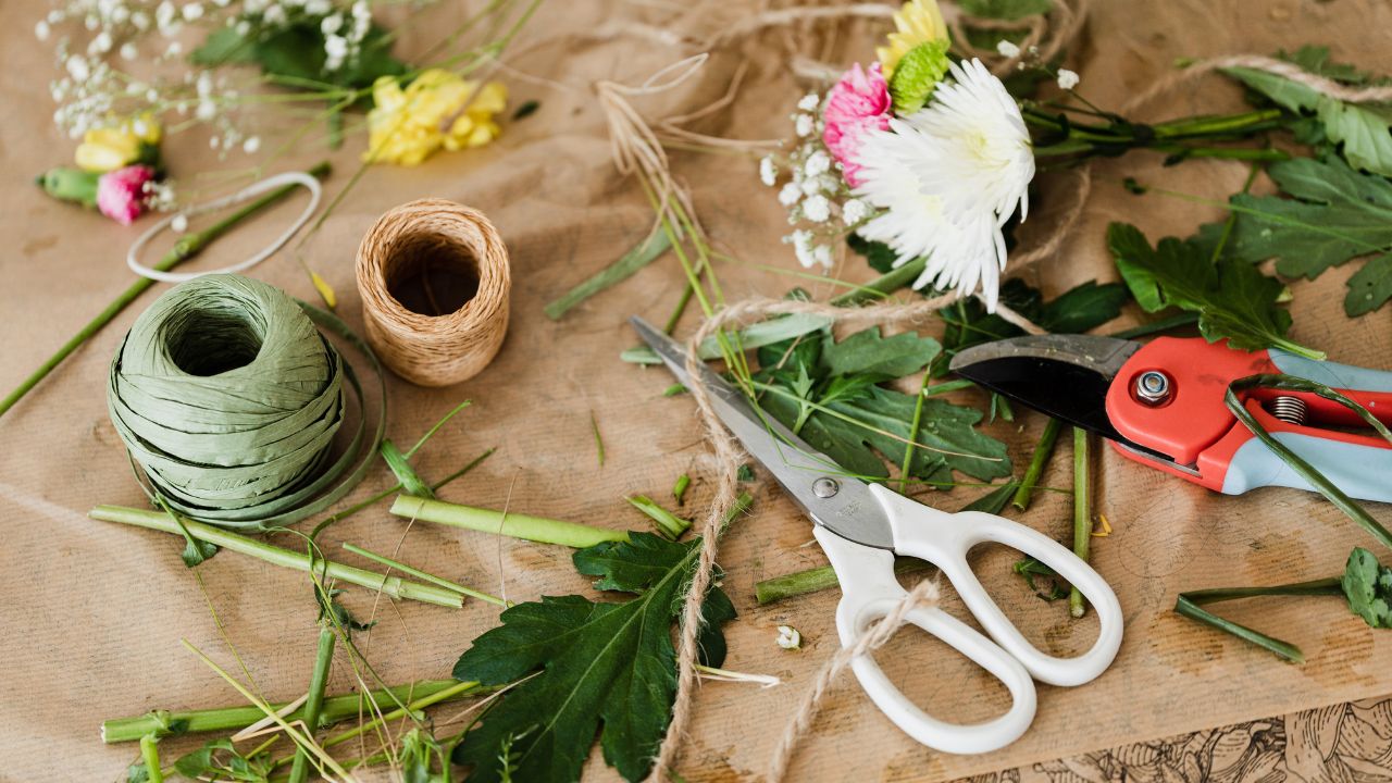leaves and flowers scattered on a table with craft supplies