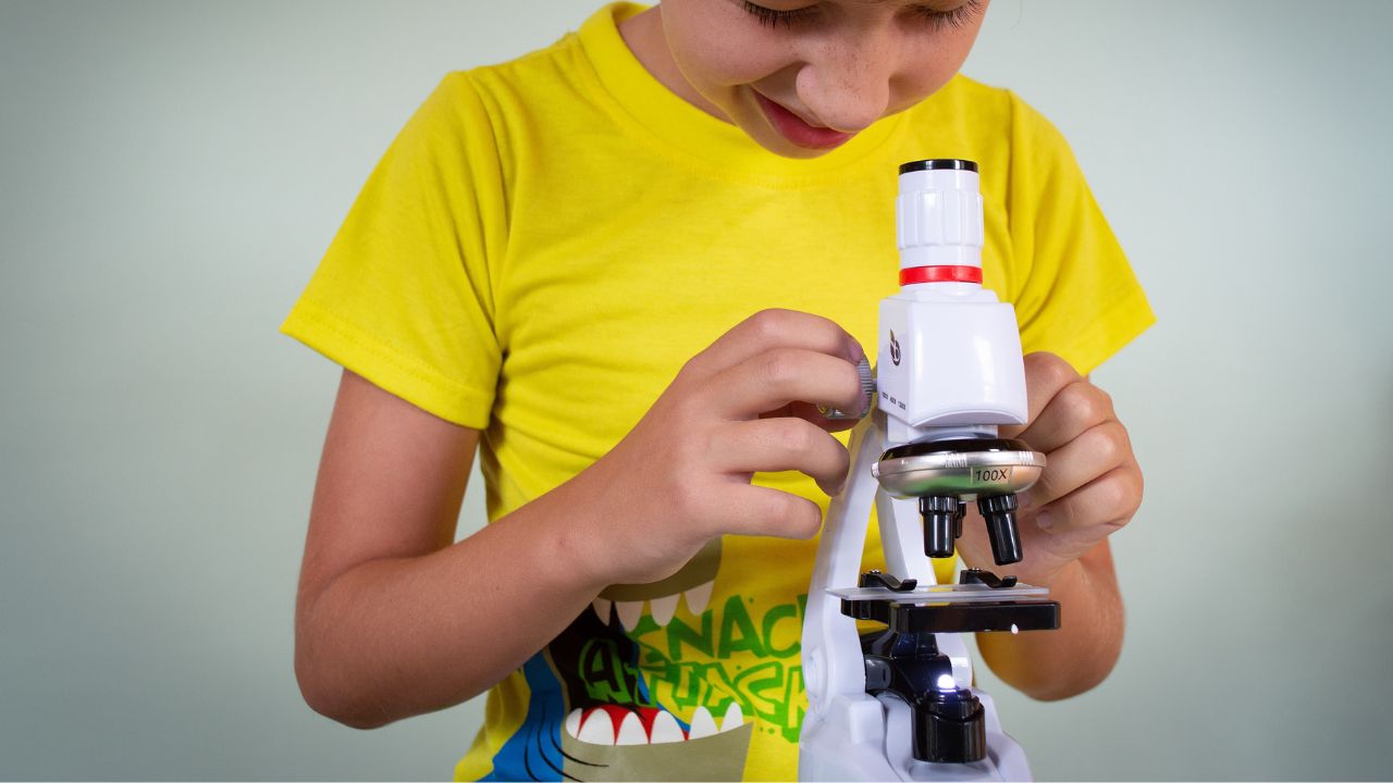 kid looking through microscope